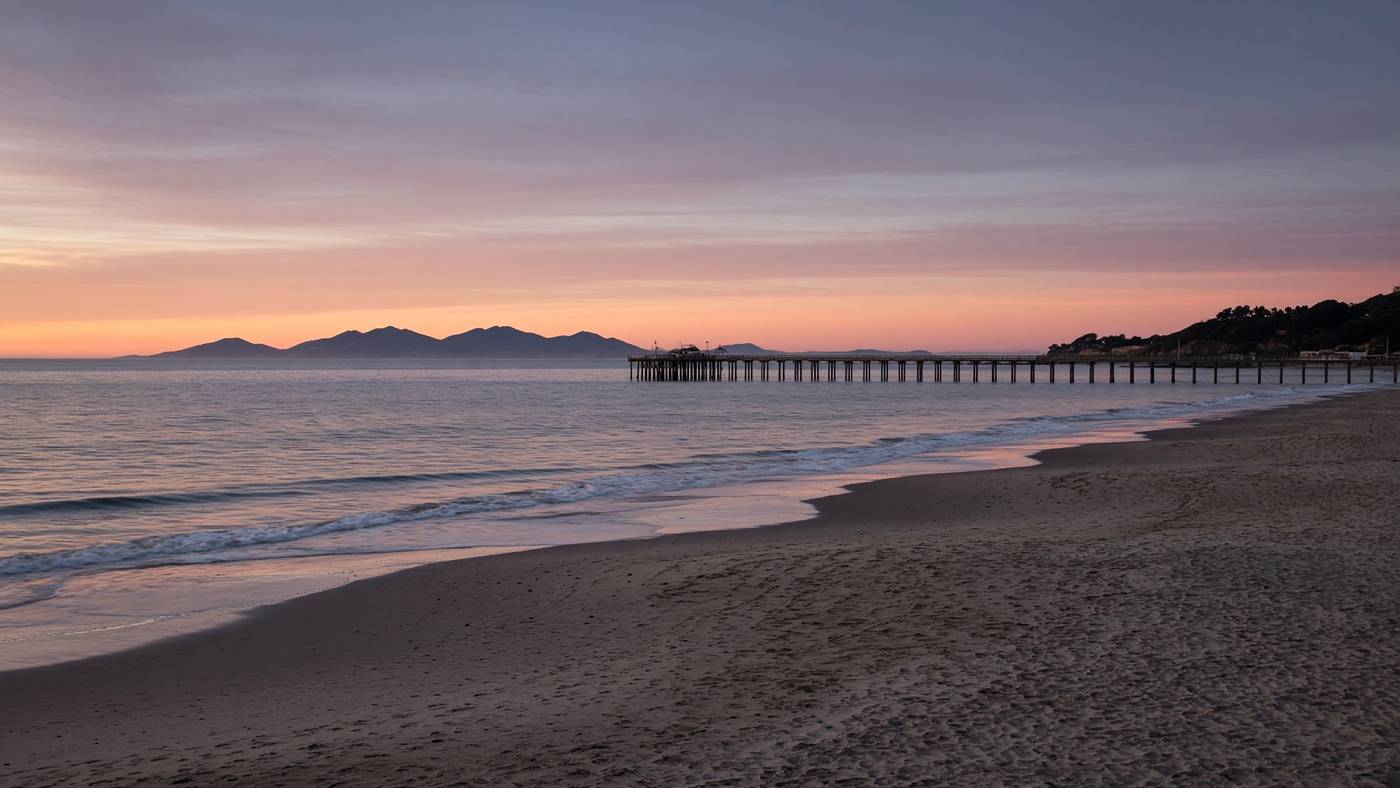 Ventura beach at last light with a distant pier and island silhouette